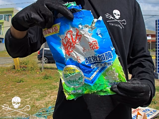 Embalagens plásticas de alimentos de outros países são carregados pelas correntes marinhas até chegarem na beira da praia.