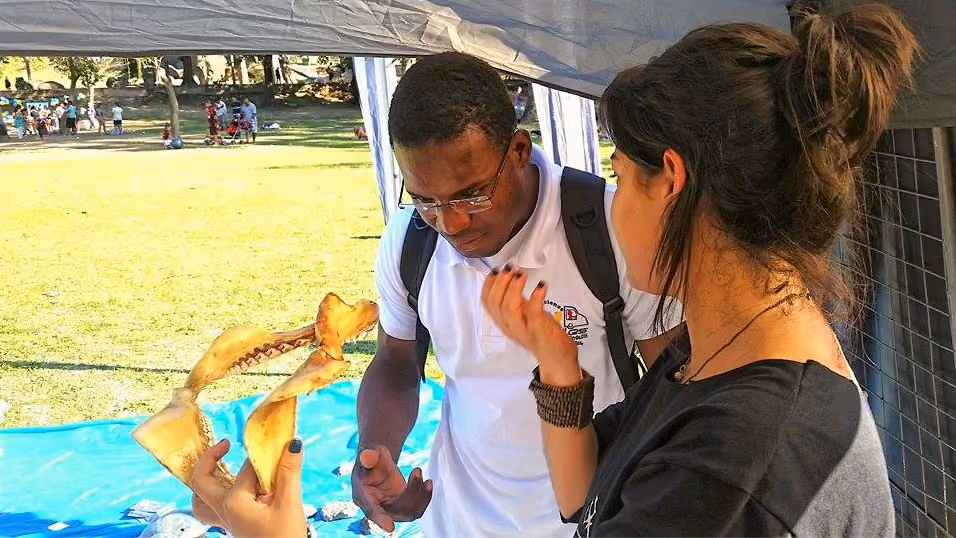 Visitante recebendo informações de Luísa Sanches. Foto:ISSB Núcleo RJ