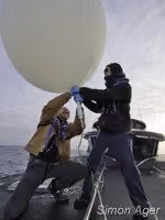 Os tripulantes Larry Routledge e Ben Wilson enchem um balão com gás helio