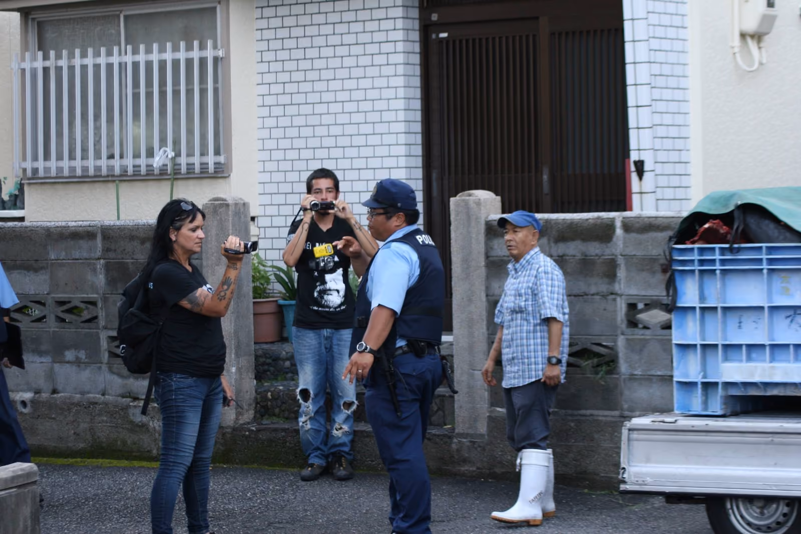 Policial tenta impedir a filmagem da caixa, cheia de carne de golfinhos, recém-comprada pelo comerciante da região (de boné azul). (Sea Shepherd Conservation Society/Cove Guardians)