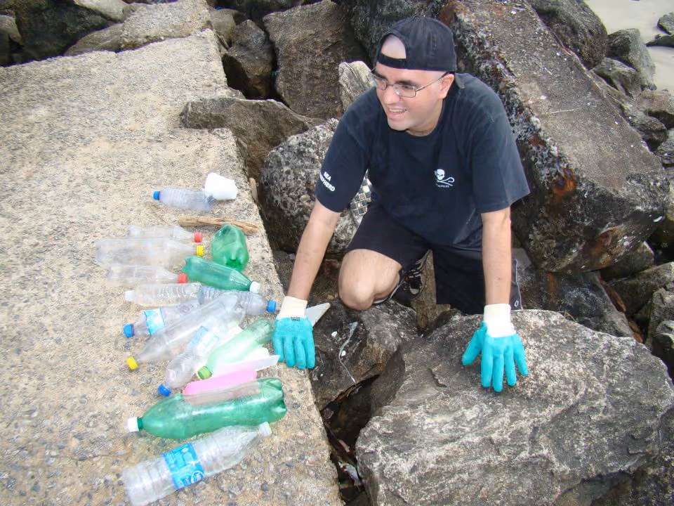 Retirando garrafas das brechas sobre a calçada que segue mar adentro.