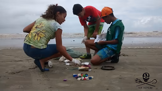 Alunos de Itanhaém recolhendo o lixo e informações para o formulário dos dados coletados.