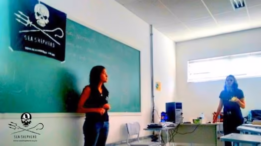 Voluntárias Dayuri Priolean e Cláudia Ferreira apresentando a ONG aos alunos de biologia.