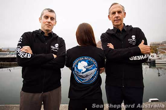 Os líderes da campanha, Jeff Hansen e Bob Brown, com um membro da tripulação vestindo uma camiseta com o símbolo da Operação Sem Piedade