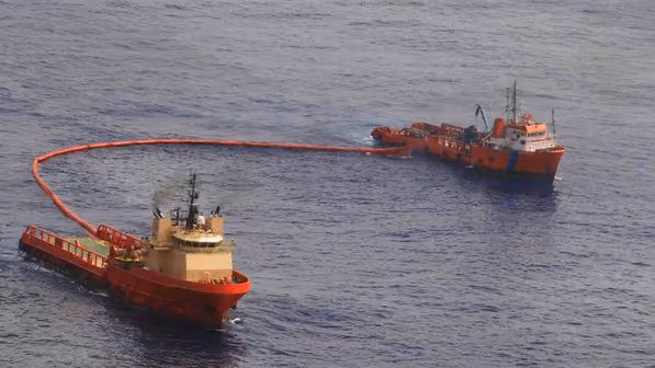 Barcos montam barragem contra vazamento de óleo. Foto: Reuters/Veja